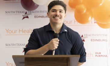 Javen Hinojosa holding a microphone